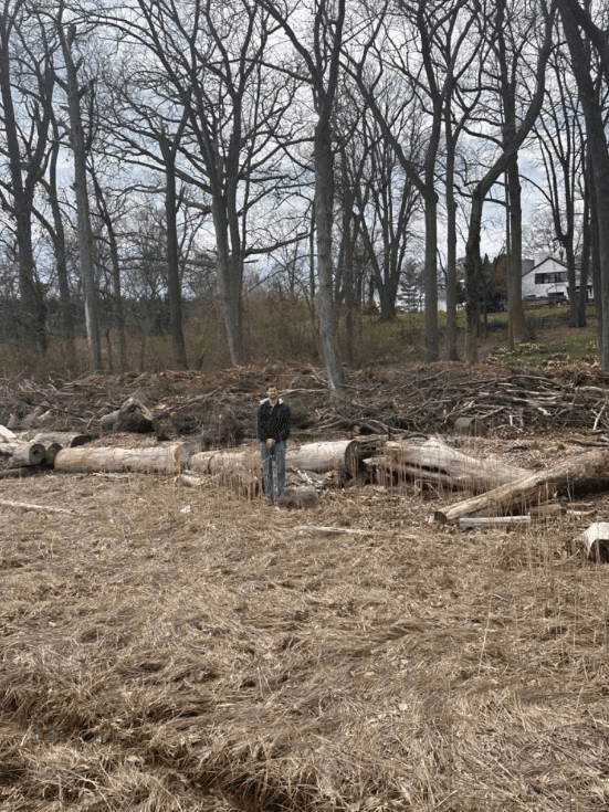 6'6" person standing at log wall for scale